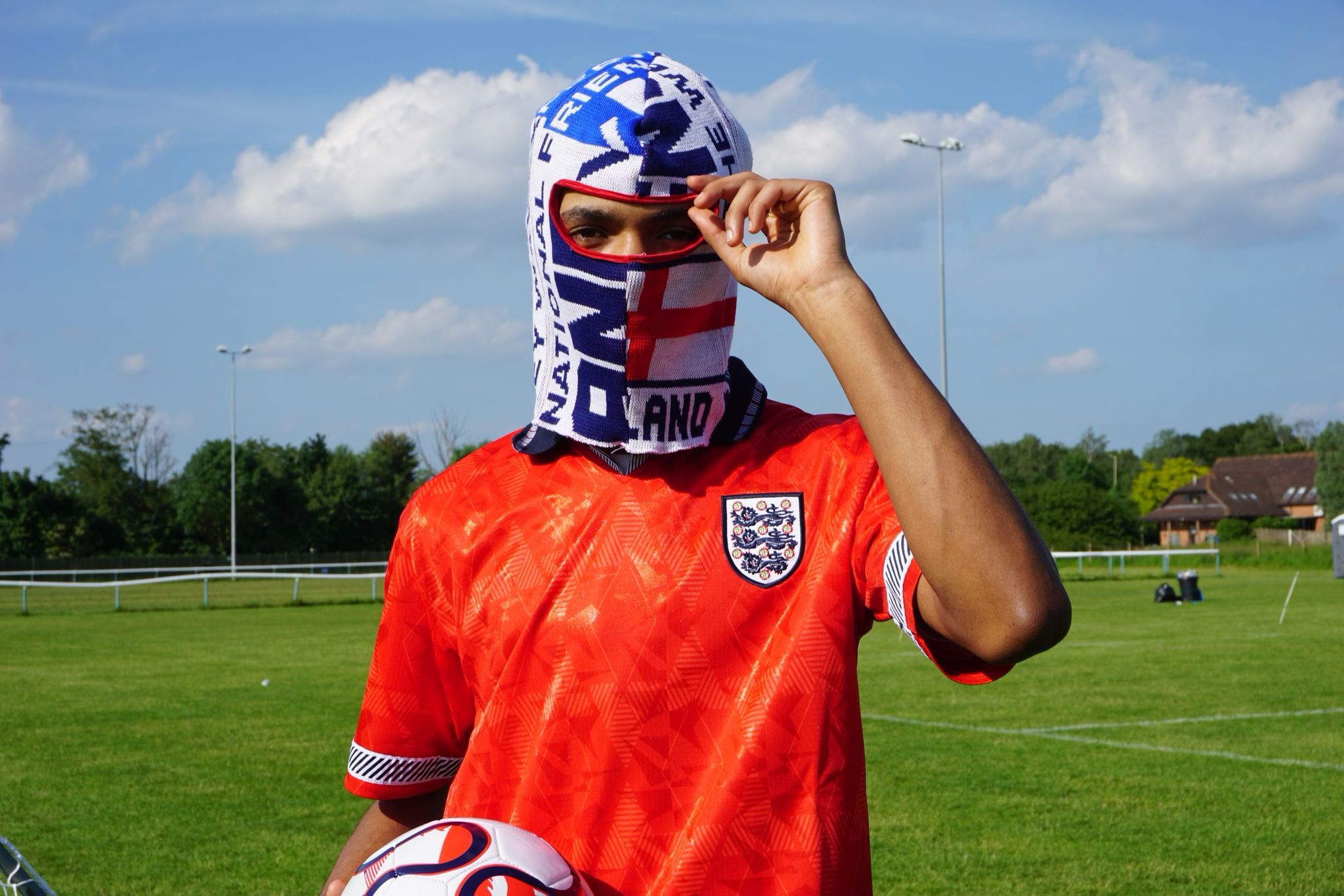 Our model wearing our England football scarf balaclava holding a football